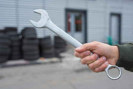 Hand auto mechanic and wrench on the background of the garage. Auto repair concept.の写真素材