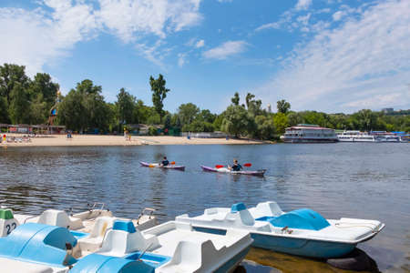 Kiev, Ukraine, May 30, 2019: People on a city beach by the river, on a sunny day. Beach season. Boat...