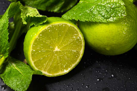 Fresh fruit close-up. Lime and mint leaves on a dark background.
