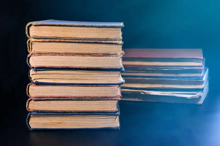 A stack of old books on a dark background. Close-up.