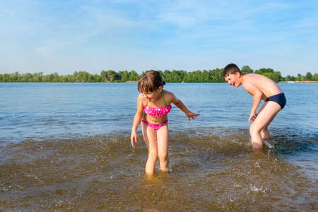 Happy children playing on the beach during the daytime. Water games.の写真素材