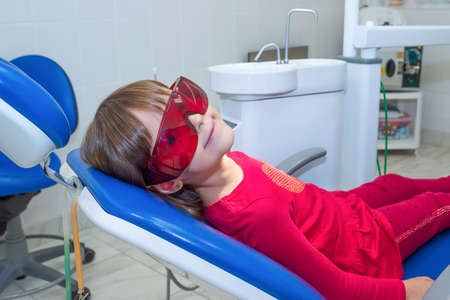 Child patient in goggles, sitting in the dental chairの写真素材