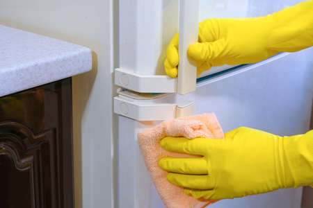 House cleaning, closeup of gloved hands rubbing dust in the kitchen.