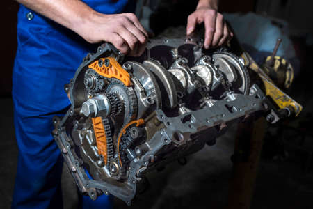 Hands auto mechanic and engine parts close-up. Car service.