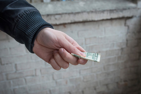 The buyer transfers the money to the dealer in exchange for a dose of the drug, close-up.の写真素材