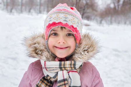 Outdoor portrait of a little girl in winter in the forest. Winter holidays, active lifestyle.の写真素材