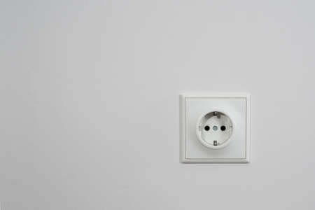 The electric socket on a white wall.の写真素材