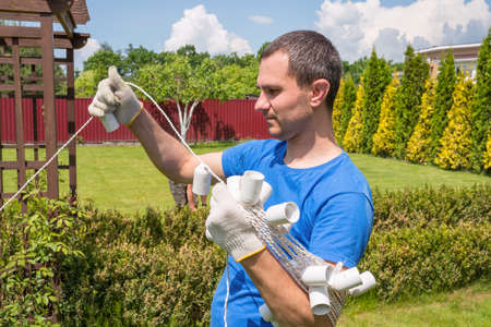 A man works in the garden on a sunny day. Cleaning the area outdoors.