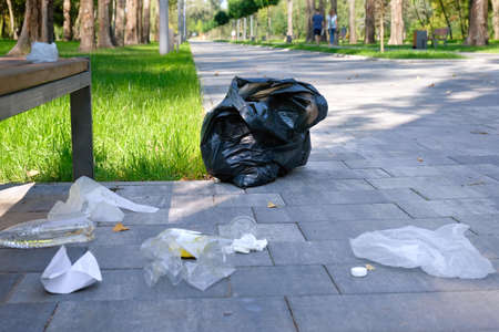 Garbage from plastic bottles, bags, paper, in the city park. Environmental pollution, environmental...