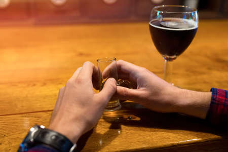 The concept of alcoholism, the fight against alcohol addiction, crisis, depression. Alcohol in hands...