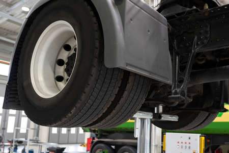 Truck on a lift in a car service. Service maintenance of trucks. Car being serviced in the garage. Close-up.の写真素材