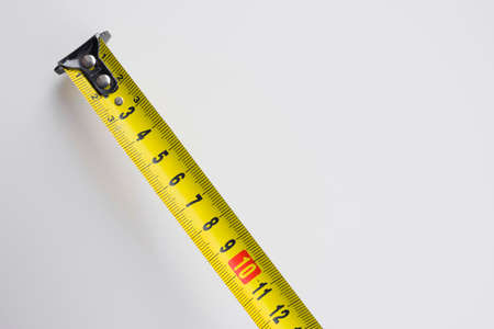 Yellow measuring tape on a white background. Close-up.の写真素材