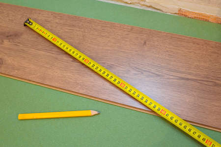 Parquet board close-up. Samples and tape measure and pencil. Repair concept.の写真素材