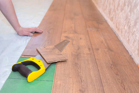 Man installs a new laminated wood floor. Home repair concept.の写真素材