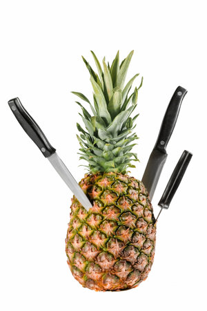 Pineapple with knives Isolated on a white background. Fresh fruits.の写真素材
