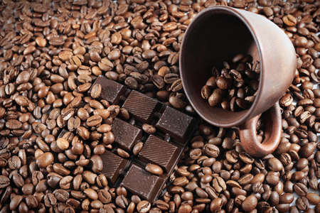 Coffee beans with a broken chocolate slice closeup. Chocolate coffee background.の写真素材