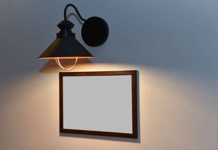 The frame without image hangs under the lamp in an interior.の写真素材