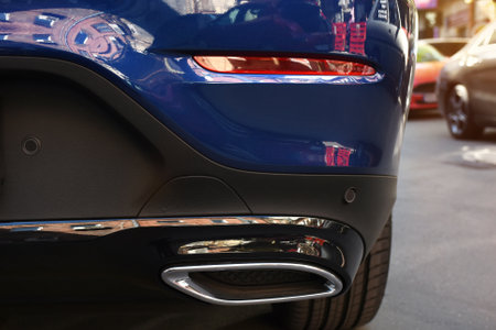 Exhaust pipe of the sports car close up standing on the street.