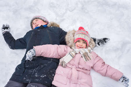 Children play outdoors in winter. Winter vacationの写真素材