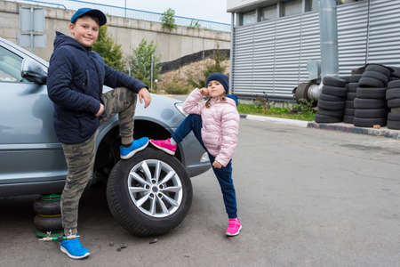 Happy child at car service posing on camera. Repair service. Automobile Repair Service Concept.の写真素材