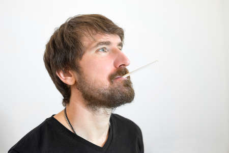 Portrait of a smoking man on a white background. Depression, despair, crisis, drug addiction and drug abuse conceptの写真素材