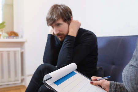 A person shares his problems with a therapist. Social issues, healthcare concept.の写真素材