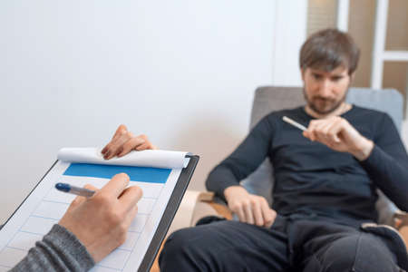 A man at a consultation in a psychologists office. Emotional health problems.の写真素材