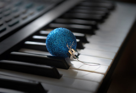 A blue bauble is lying among the synthesizer keys.の写真素材