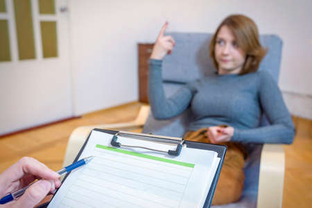 A young woman at a reception with a psychologist talks about her problems. ... Consultation with a doctor. Healthcare concept.の写真素材