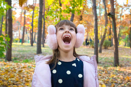 Happy autumn outdoor portrait of a girl in the park on a sunny day.