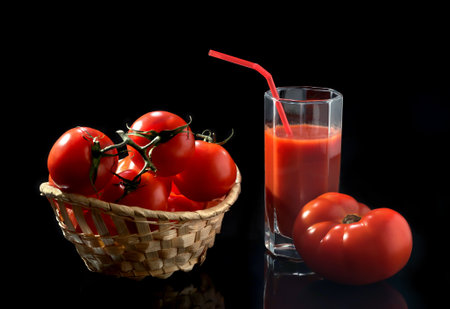 Fresh tomatoes in a basket on a black backgroundの写真素材