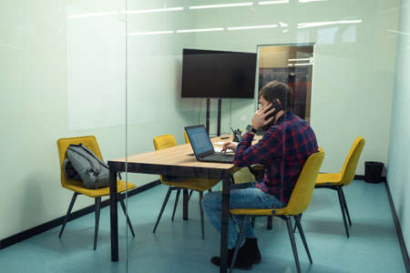 A young man works in the office at the computer. Co-working, Business and entrepreneurship concept....