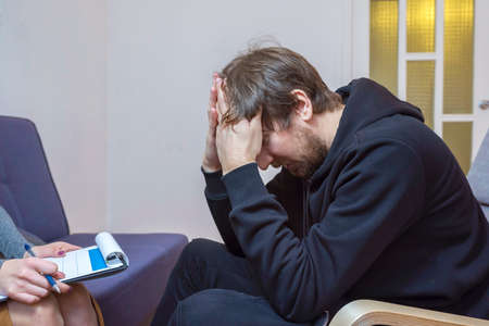 A man in the office of a psychotherapist. A person shares with a psychologist about his problems,...