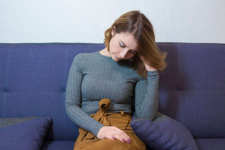 Girl sitting on a sofa in the office of a psychologist talks about her problems. The concept of a psychological consultant.の写真素材