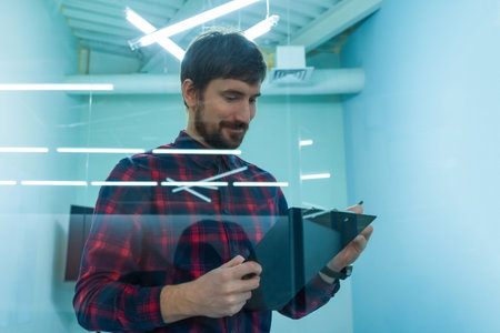 Portrait of a young businessman working in office with documents. Man in the office reads a new...