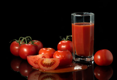Fresh juicy tomatoes on a black background.の写真素材