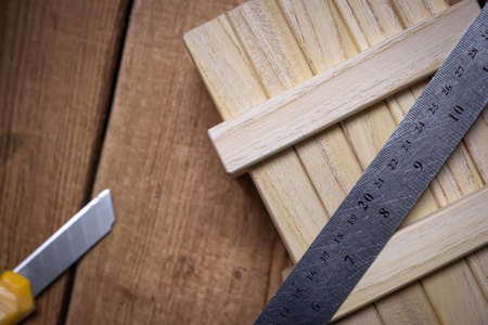 Working tools ruler and stationery knife on a working wooden table.の写真素材