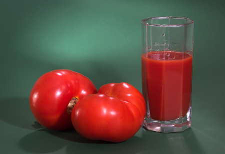 Red tomatoes and tomato juice on a green background,の写真素材