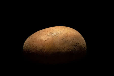 Raw potatoes on a black background. Organic products in the studio.