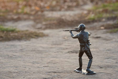 War concept. Armed toy soldier outdoors. Side view.の写真素材