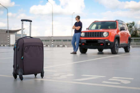 Vacation concept. Suitcase in car parking close-up.の写真素材