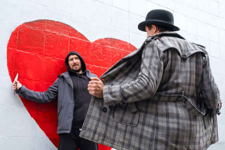 Male exhibitionist scaring a robber with a knife on the streetの写真素材