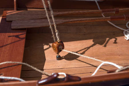 Old wooden sailboat pulleys and ropes detail.