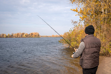 A fisherman with spinning rods in his hands is fishing on the bay. Fishingの写真素材