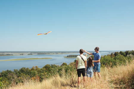 Happy family flying a kite outdoors. Family on summer vacationの写真素材
