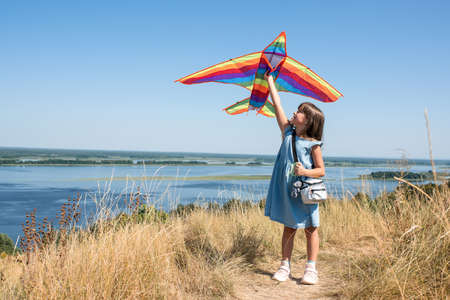 Happy girl playing with a kite in nature. Golden hourの写真素材