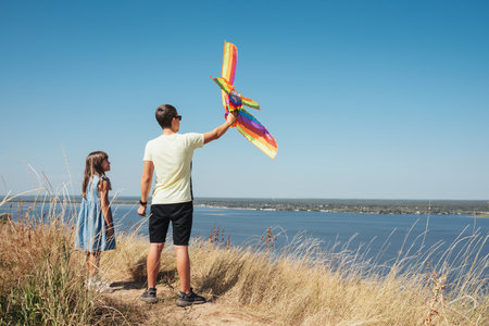 Children play in nature, launching a kite into the skyの写真素材
