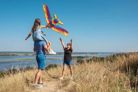 Happy family in nature launch a kite into the skyの写真素材