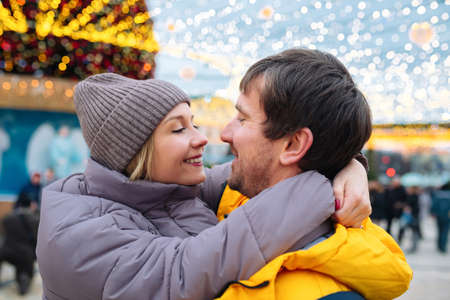 Happy young people in love hugging on the city street on christmas daysの写真素材