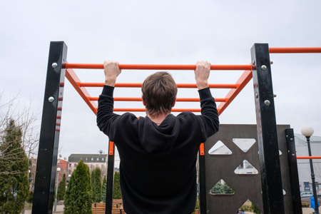 A young man is engaged in a sport on the playground in the park. Fitness, sport, healthy lifestyleの写真素材